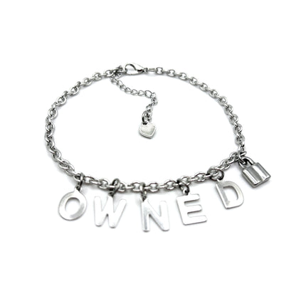 Silver chain bracelet with 'OWNED U' charms on a white background